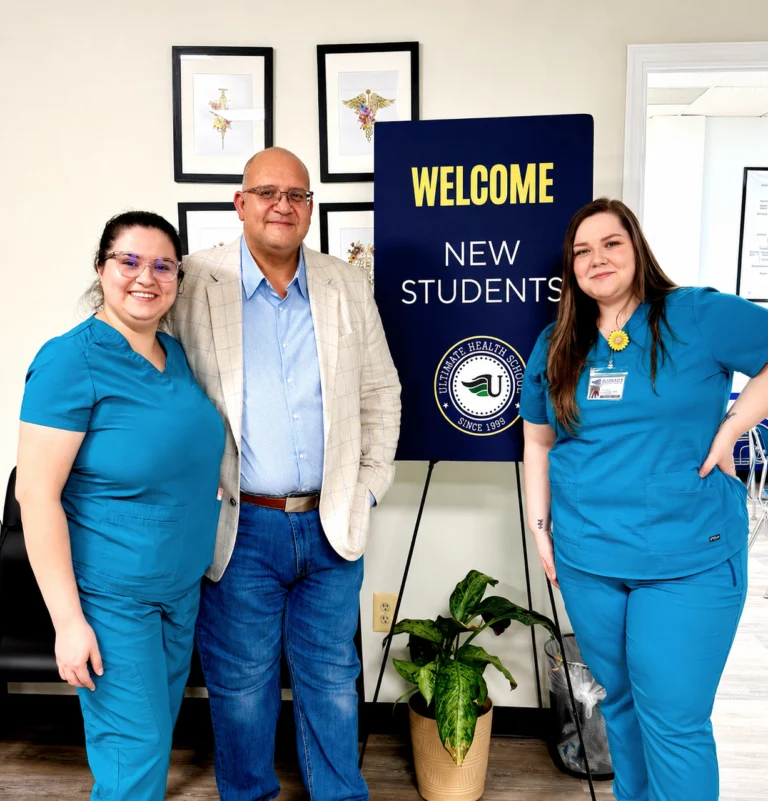 Three people standing beside a welcome sign for new students.